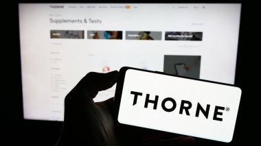 Stuttgart, Almanya - 08-05-2023: ABD 'li sağlık şirketi Thorne HealthTech Inc.' in logosuyla cep telefonu sahibi kişi iş sayfasının önünde ekranda. Telefon ekranına odaklan.