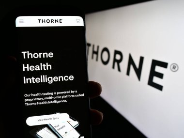 Stuttgart, Almanya - 08-05-2023: ABD 'li sağlık şirketi Thorne HealthTech Inc.' in web sayfası ile akıllı telefon sahibi kişi logolu ekranda. Telefon ekranının merkezine odaklan.