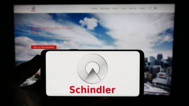 Stuttgart, Almanya - 08-05-2023: İsviçreli asansör şirketi Schindler Group 'un logosunu taşıyan kişi web sitesinin önünde ekranda. Telefon ekranına odaklan.