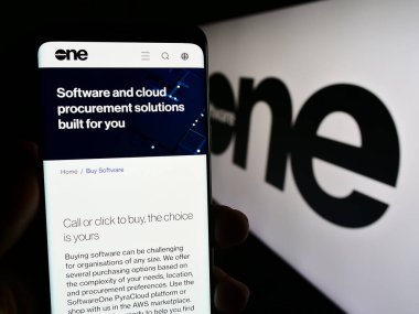 Stuttgart, Almanya - 08-05-2023: İsviçreli yazılım şirketi SoftwareOne AG 'nin web sayfası ile cep telefonu tutan kişi logonun önünde ekranda. Telefon ekranının merkezine odaklan.