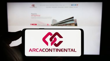 Stuttgart, Almanya - 08-05-2023: Arca Continental S.A.B. şirketinin logosuyla cep telefonu tutan kişi De C.V. iş sayfasının önünde ekranda. Telefon ekranına odaklan.