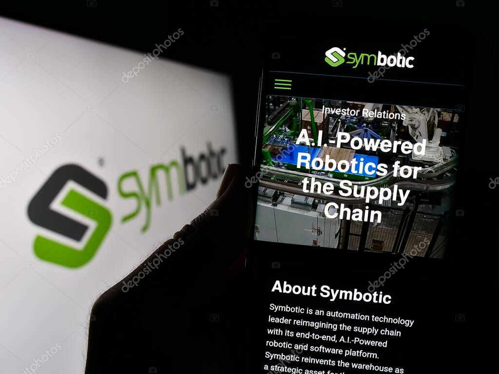 Stuttgart, Germany - 08-05-2023: Person holding smartphone with website of US robotics warehouse company Symbotic Inc. on screen with logo. Focus on center of phone display.