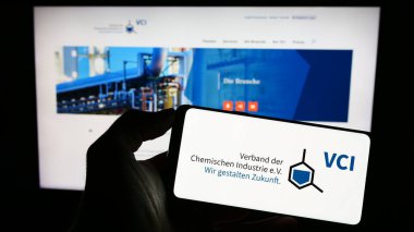Stuttgart, Almanya - 08-06-2023: Verband der Chemischen Industrie 'nin logosuna sahip cep telefonu sahibi kişi. (VCI) Web sayfasının önünde ekranda. Telefon ekranına odaklan.