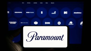 Stuttgart, Almanya - 08-06-2023: ABD 'li eğlence şirketi Paramount Global' ın logosuyla cep telefonu sahibi kişi iş dünyasının web sayfası önünde ekranda. Telefon ekranına odaklan.