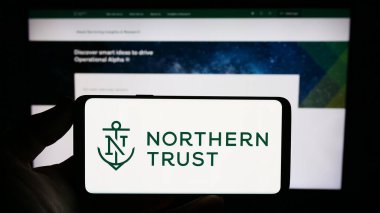 Stuttgart, Almanya - 08-06-2023: ABD 'li finans şirketi Northern Trust Corporation' ın logosunu elinde tutan kişi web sitesinin önünde ekranda. Telefon ekranına odaklan.
