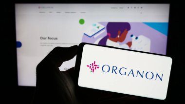 Stuttgart, Almanya - 08-06-2023: Web sayfasının önünde ekranda Amerikan ilaç firması Organon Co. 'nun logosunun bulunduğu cep telefonu sahibi kişi. Telefon ekranına odaklan.