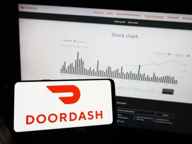 Stuttgart, Almanya - 07-25-2023: Amerikan gıda dağıtım şirketi DoorDash Inc. 'in logosunun bulunduğu cep telefonu web sayfasının önünde duruyor. Telefon ekranına odaklan.