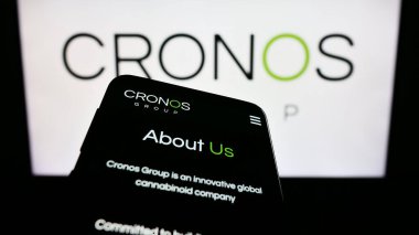 Stuttgart, Almanya - 07-24-2023: İş logosu önünde ekranda Kanadalı esrar şirketi Cronos Group Inc. ile cep telefonu. Telefon ekranının sol üst kısmına odaklan.