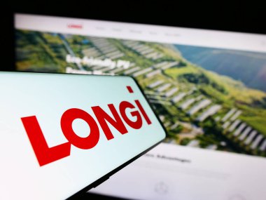 Stuttgart, Almanya - 07-22-2023: LONGi Green Energy Technology Co. Ltd. şirketinin logosuna sahip akıllı telefon, iş dünyasının web sitesi önünde ekranda. Telefon ekranının merkezine odaklan.
