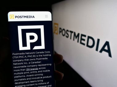 Stuttgart, Almanya - 07-21-2023: Medya şirketi Postmedia Network Canada Corp 'un internet sayfası ile akıllı telefonu elinde tutan kişi logolu ekranda. Telefon ekranının merkezine odaklan.