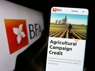 Stuttgart, Almanya - 07-21-2023: Finans şirketi Banco de Fomento Angola 'nın (BFA) internet sitesi ile akıllı telefon sahibi kişi logo ile ekranda görülüyor. Telefon ekranının merkezine odaklan.