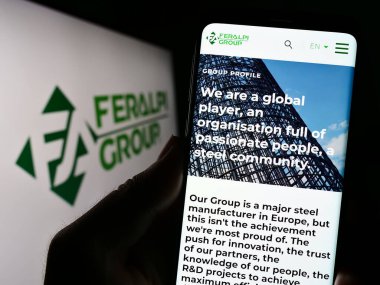 Stuttgart, Almanya - 07-21-2023: İtalyan çelik şirketi Feralpi Group 'un web sayfası olan cep telefonu logonun önünde ekranda. Telefon ekranının merkezine odaklan.