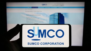 Stuttgart, Germany - 07-21-2023: Person holding smartphone with logo of Japanese semiconductor company SUMCO Corporation on screen in front of website. Focus on phone display. clipart