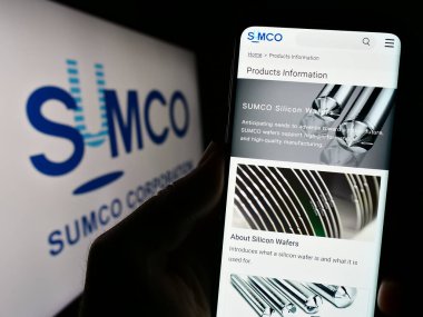 Stuttgart, Almanya - 07-21-2023: Japon yarı iletken şirketi SUMCO Corporation 'ın web sayfası ile birlikte logolu cep telefonu tutan kişi. Telefon ekranının merkezine odaklan.