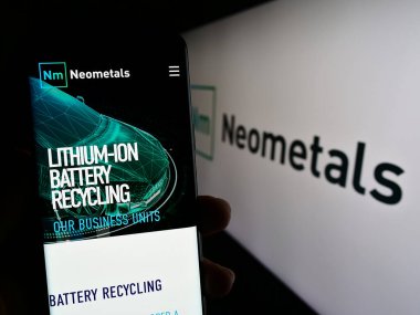 Stuttgart, Almanya - 07-21-2023: Avustralyalı batarya şirketi Neometals Ltd. 'nin web sitesi ile logo önünde cep telefonu tutan kişi. Telefon ekranının merkezine odaklan.