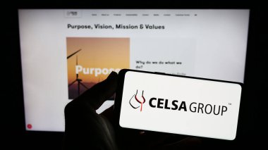 Stuttgart, Almanya - 07-21-2023: İspanyol çelik şirketi CELSA Group 'un logosunu elinde tutan kişi web sitesinin önünde ekranda. Telefon ekranına odaklan.