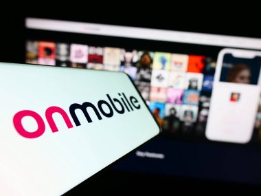 Stuttgart, Almanya - 07-19-2023: Hint şirketi OnMobile Global Limited 'in logosunun yer aldığı cep telefonu iş sitesinin önünde ekranda. Telefon ekranının merkezine odaklan.