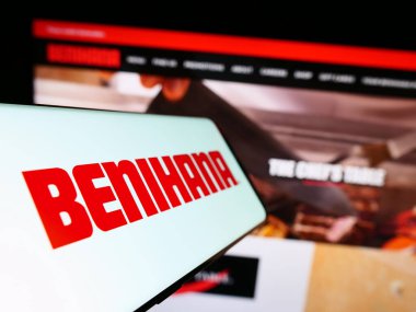 Stuttgart, Almanya - 07-19-2023: Amerikan restoran şirketi Benihana Inc. 'in logosunu içeren akıllı telefon iş sitesinin önünde ekranda. Telefon ekranının merkez soluna odaklan.