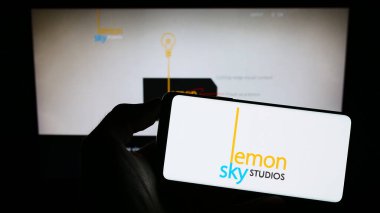 Stuttgart, Almanya - 07-19-2023: İnternet sayfası önünde ekranda Malezyalı video oyunları şirketi Lemon Sky Studios 'un logosunu elinde tutan kişi. Telefon ekranına odaklan.