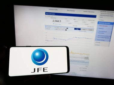 Stuttgart, Almanya - 07-19-2023: Japon çelik şirketi JFE Holding Inc. 'nin logosunu elinde tutan kişi web sitesinin önünde ekranda. Telefon ekranına odaklan.