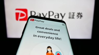 Stuttgart, Almanya - 07-19-2023: Japon ödeme şirketi PayPay Corporation 'ın web sitesi ile cep telefonu iş logosu önünde ekranda. Telefon ekranının sol üst kısmına odaklan.