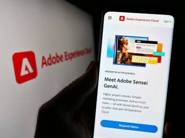 Stuttgart, Almanya - 07-15-2023: Yazılım ürünü Adobe Experience Cloud 'un (AEC) web sayfasını elinde tutan kişi logo ile ekranda. Telefon ekranının merkezine odaklan.