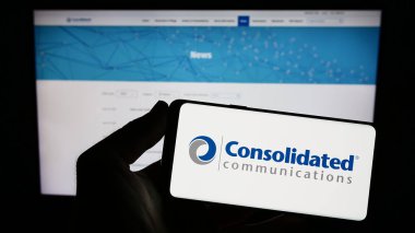 Stuttgart, Germany - 07-15-2023: Person holding smartphone with logo of company Consolidated Communications Holdings Inc. on screen in front of website. Focus on phone display. clipart