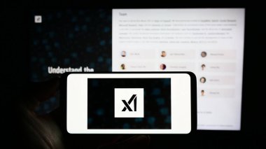 Stuttgart, Almanya - 07-15-2023: Web sayfasının önünde üzerinde Amerikan Yapay Zeka Şirketi XAI Corp logosu bulunan cep telefonu sahibi kişi. Telefon ekranına odaklan.
