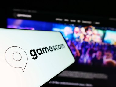 Stuttgart, Almanya - 07-15-2023: Ticari İnternet sitesi önünde ekranda Alman video oyunu fuarı fuarı (Köln) logosu bulunan cep telefonu. Telefon ekranının soluna odaklan.