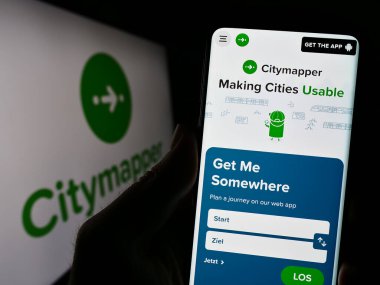 Stuttgart, Almanya - 07-14-2023: Toplu taşıma uygulaması şirketi Citymapper Limited 'in web sitesine sahip akıllı telefon sahibi kişi logo ile ekranda görülüyor. Telefon ekranının merkezine odaklan.