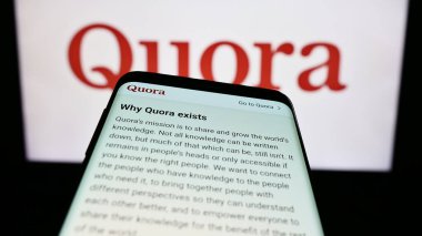 Stuttgart, Almanya - 07-13-2023: İş logosu önünde ekranda ABD 'li soru-cevap şirketi Quora Inc.' nin web sitesi bulunan cep telefonu. Telefon ekranının sol üst kısmına odaklan.
