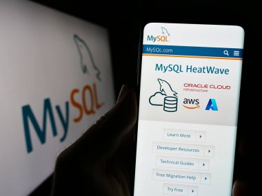 Stuttgart, Almanya - 07-13-2023: İlişkisel veritabanı yönetim sistemi web sitesi olan cep telefonu logosu önünde ekranda. Telefon ekranının merkezine odaklan.