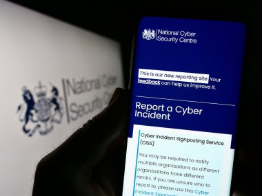 Stuttgart, Almanya - 07-13-2023: Logo önünde ekranda Birleşik Krallık Ulusal Siber Güvenlik Merkezi (NCSC) web sitesi bulunan kişi. Telefon ekranının merkezine odaklan.