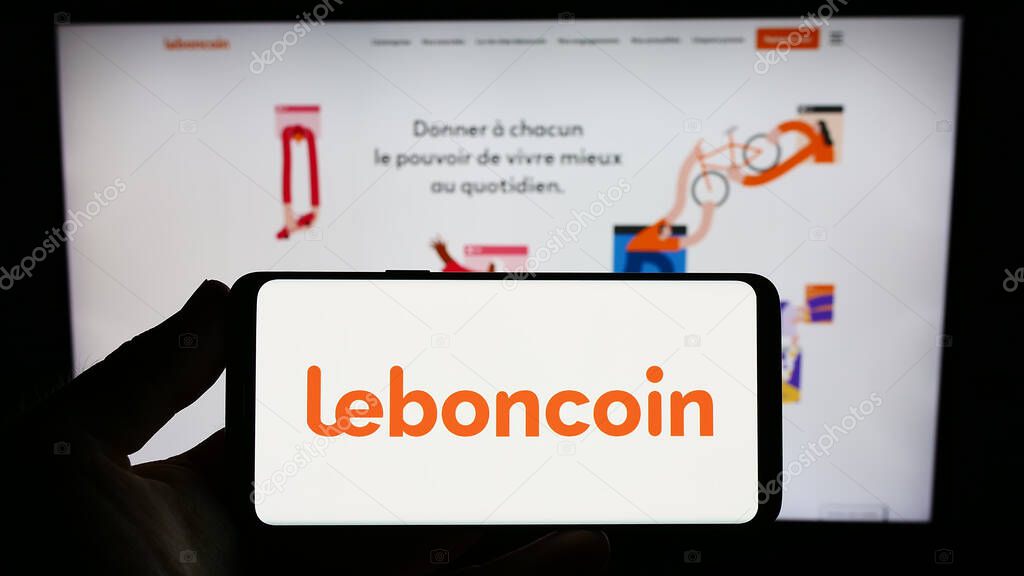 Stuttgart, Germany - 07-13-2023: Person holding smartphone with logo of French classified ads company Leboncoin on screen in front of website. Focus on phone display.