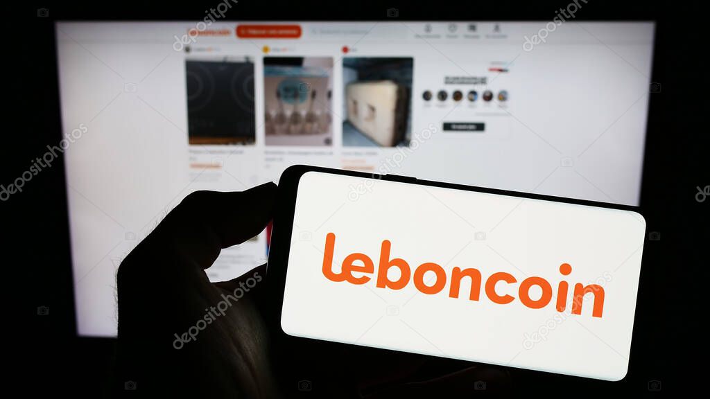 Stuttgart, Germany - 07-13-2023: Person holding cellphone with logo of French classified ads company Leboncoin on screen in front of business webpage. Focus on phone display.