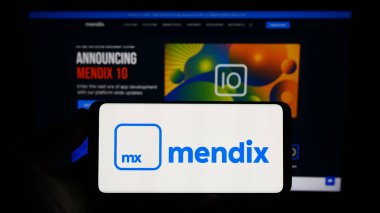 Stuttgart, Almanya - 07-12-2023: Yazılım şirketi Medix Technology B.V. 'nin logosunu elinde tutan kişi web sitesinin önünde ekranda. Telefon ekranına odaklan.