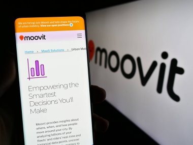 Stuttgart, Almanya - 07-12-2023: İsrailli taşınabilirlik şirketi Moovit Inc. 'in web sayfasını elinde tutan kişi logonun önünde ekranda. Telefon ekranının merkezine odaklan.
