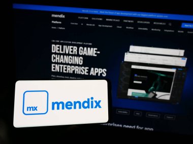 Stuttgart, Almanya - 07-12-2023: İçinde yazılım şirketi Medix Technology BV 'nin logosu olan cep telefonu olan kişi iş sayfasının önünde ekranda. Telefon ekranına odaklan.