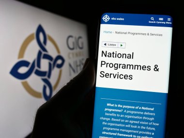 Stuttgart, Almanya - 07-12-2023: İngiliz sağlık sistemi NHS Wales 'in web sayfası olan cep telefonu logonun önünde ekranda. Telefon ekranının merkezine odaklan.