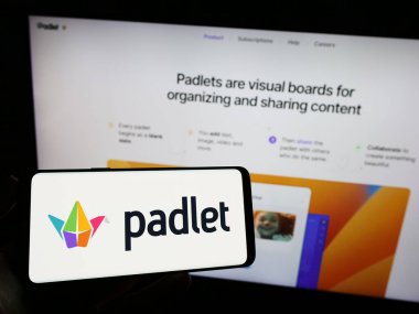 Stuttgart, Almanya - 07-11-2023: Edtech şirketi Wallwisher Inc. 'in logosuna sahip cep telefonu sahibi kişi iş sayfasının önünde ekranda. Telefon ekranına odaklan.