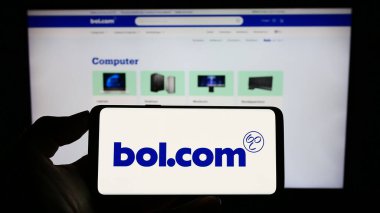 Stuttgart, Almanya - 07-11-2023: Hollandalı e-ticaret şirketi bol.com B.V. 'nin logosunun bulunduğu cep telefonu sahibi kişi iş sayfasının önünde ekranda. Telefon ekranına odaklan.