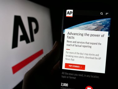 Stuttgart, Almanya - 07-11-2023: ABD 'li haber ajansı Associated Press' in (AP) web sitesi ile cep telefonunu logo önünde tutan kişi. Telefon ekranının merkezine odaklan.