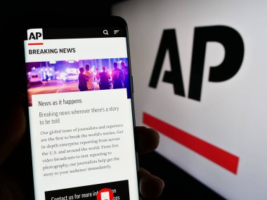Stuttgart, Almanya - 07-11-2023: ABD 'li haber ajansı Associated Press' in (AP) web sitesi ile akıllı telefonu logo önünde tutan kişi. Telefon ekranının merkezine odaklan.