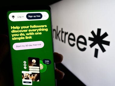 Stuttgart, Almanya - 07-09-2023: Avustralyalı İnternet şirketi Linktree Pty 'nin internet sitesinden cep telefonu tutan kişi. Ltd. Ekranda logo var. Telefon ekranının merkezine odaklan.