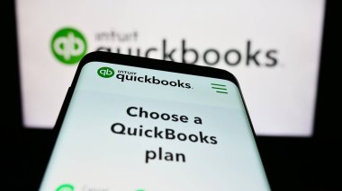 Stuttgart, Almanya - 07-09-2023: İş logosu önünde QuickBooks isimli muhasebe yazılımı web sitesi bulunan akıllı telefon. Telefon ekranının sol üst kısmına odaklan.