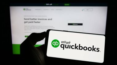 Stuttgart, Almanya - 07-09-2023: Muhasebe yazılımı logosu olan cep telefonu sahibi kişi iş sayfasının önünde ekranda. Telefon ekranına odaklan.