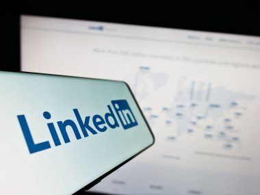 Stuttgart, Almanya - 07-09-2023: Web sitesi önünde ekranda LinkedIn Corporation adlı Amerikan sosyal medya şirketinin logosuna sahip akıllı telefon. Telefon ekranının merkezine odaklan.