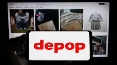 Stuttgart, Almanya - 07-09-2023: Sosyal e-ticaret şirketi Depop Limited 'in logosuna sahip cep telefonu sahibi kişi iş sayfasının önünde ekranda görülüyor. Telefon ekranına odaklan.