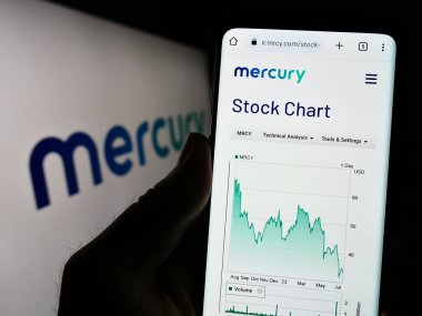 Stuttgart, Almanya - 07-08-2023: ABD 'li savunma şirketi Mercury Systems Inc.' in web sitesi ile cep telefonu tutan kişi logo önünde ekranda. Telefon ekranının merkezine odaklan.