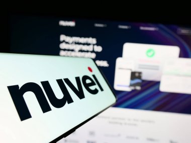 Stuttgart, Almanya - 07-08-2023: Kanadalı ödeme şirketi Nuvei Technologies Corp. 'un logosunu taşıyan cep telefonu iş dünyasının web sitesinin önünde ekranda. Telefon ekranının soluna odaklan.